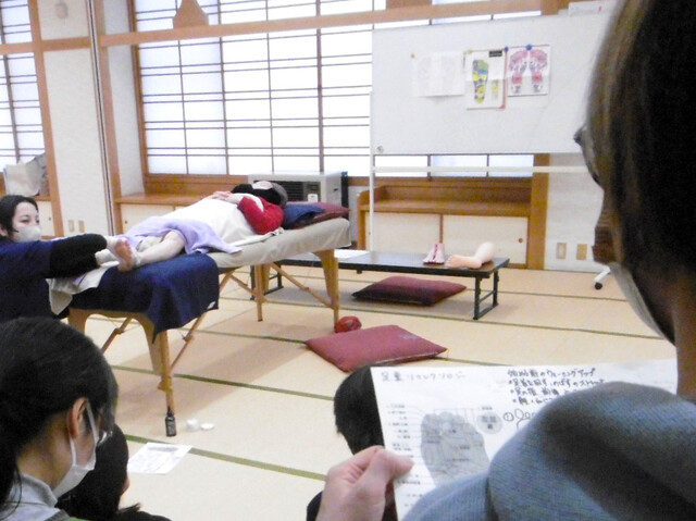2024足裏健康法1 写真:リフレクソロジーの手本を見せる講師