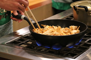 材料を炒める中野市食の大使 杉浦太陽さんの写真